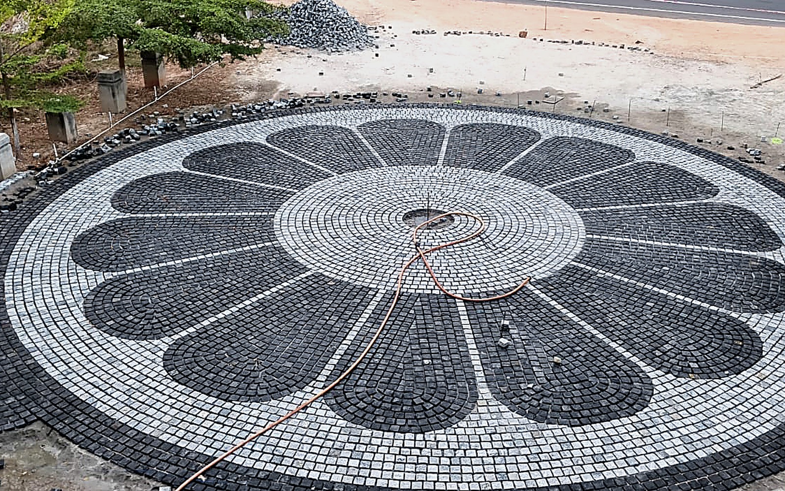 Circular cobble stone pattern installation shown as a premium outdoor feature